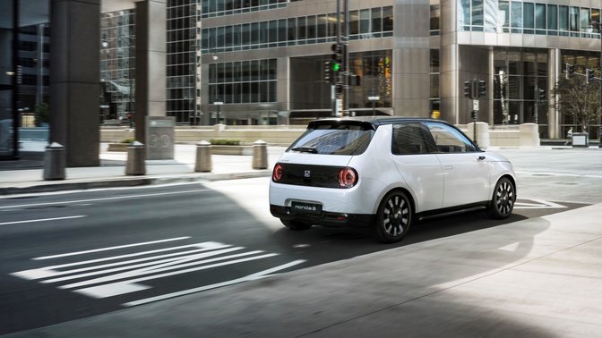 Honda e in einer Strasse mit Ampeln, 3/4-Heckansicht