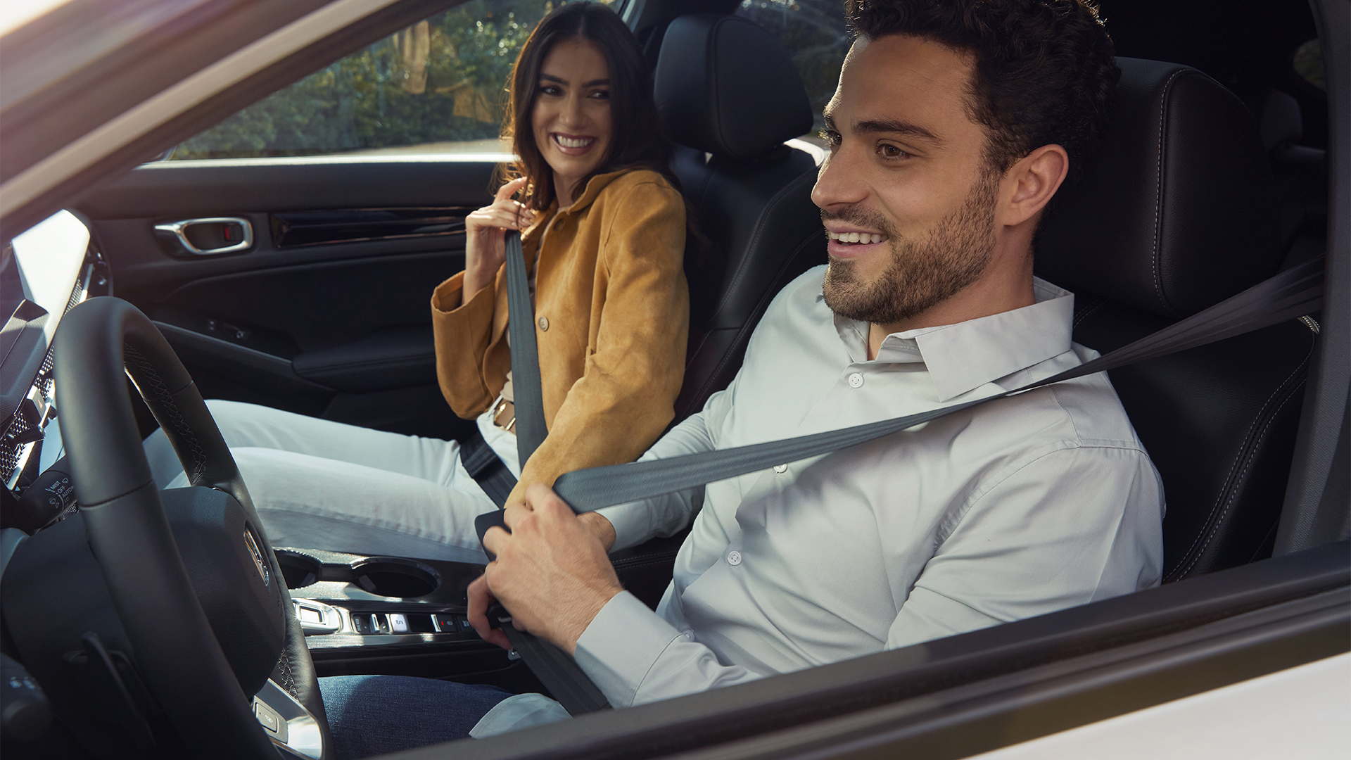 Zwei Personen schnallen sich im Inneren des Honda Civic Hybrid an.