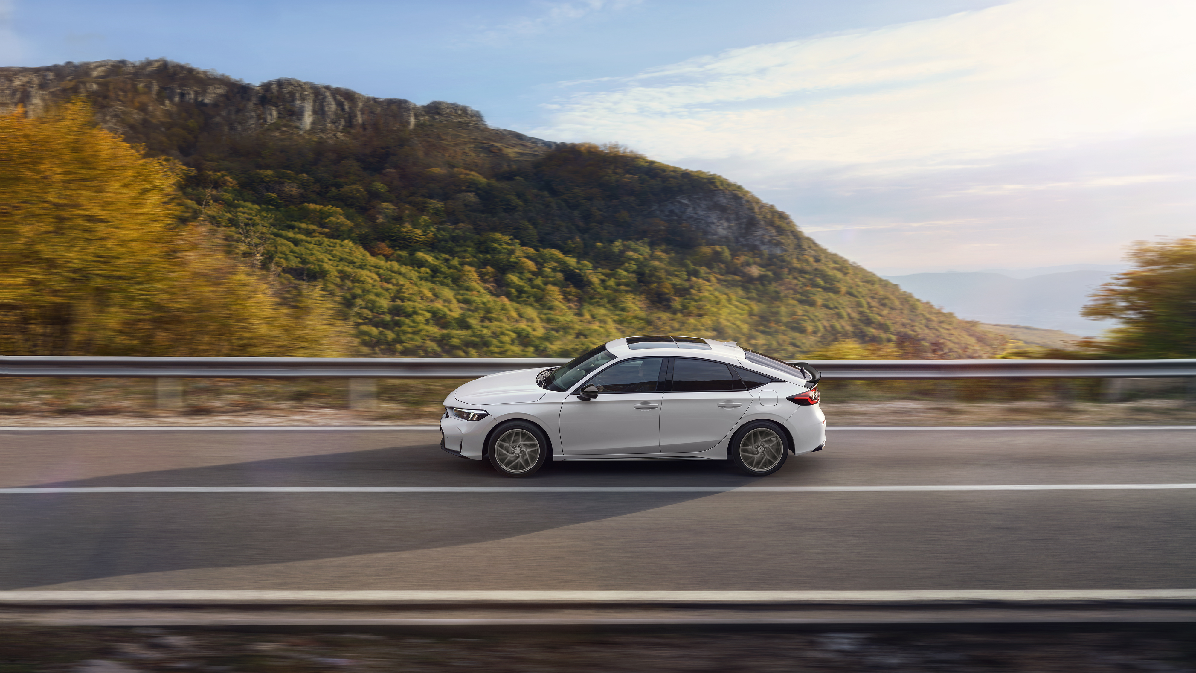 Honda Civic Hybrid in Bewegung auf einer Autobahn, mit Blick auf die Landschaft.