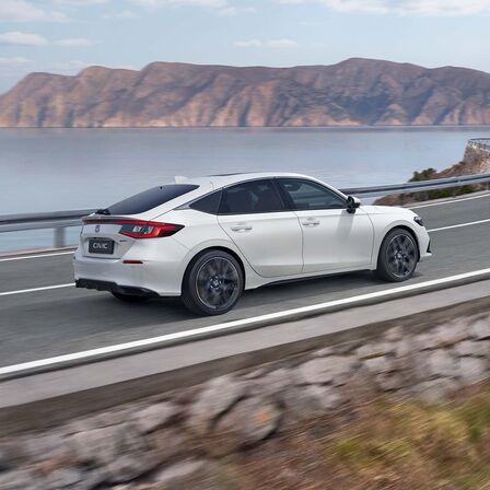 Honda Civic e:HEV auf Küstenstraße, Seitenansicht.
