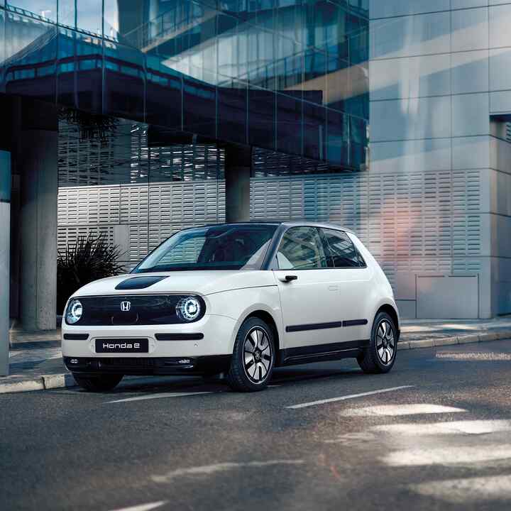 Honda e auf der Strasse mit Gebäuden im Hintergrund