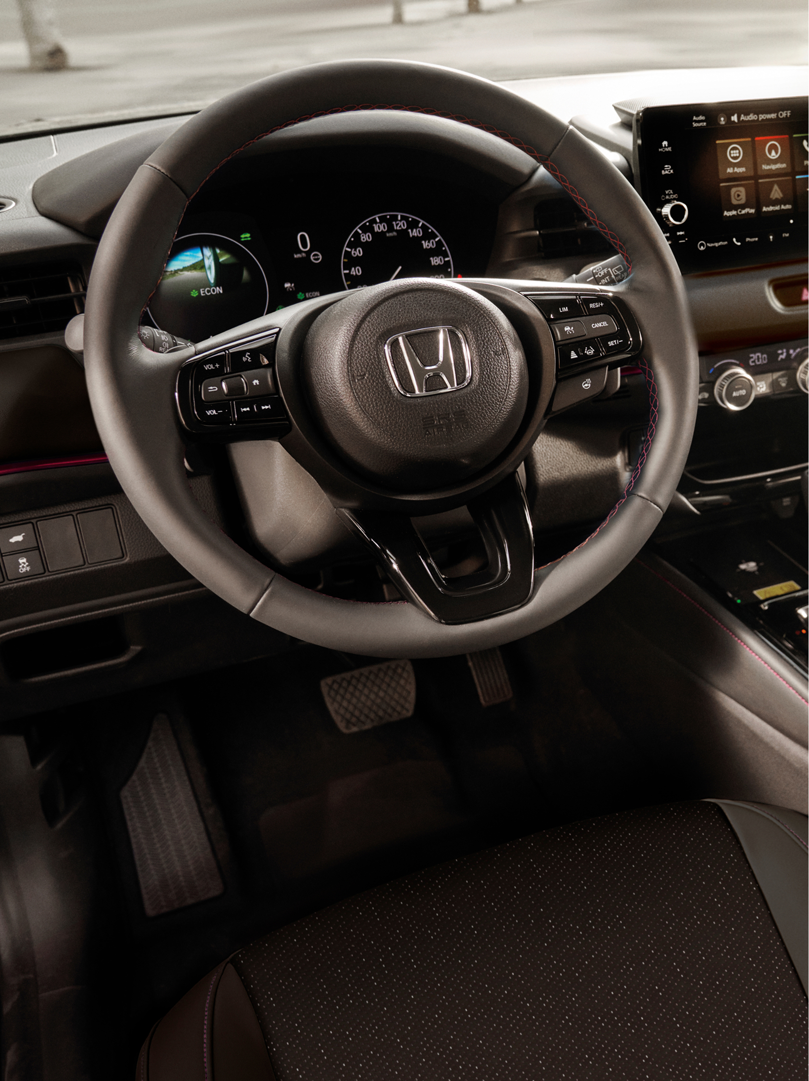 Innenraum eines Honda HR-V mit Lenkrad, digitalem Kombiinstrument, zentralem Touchscreen und automatischem Gangwahlhebel.