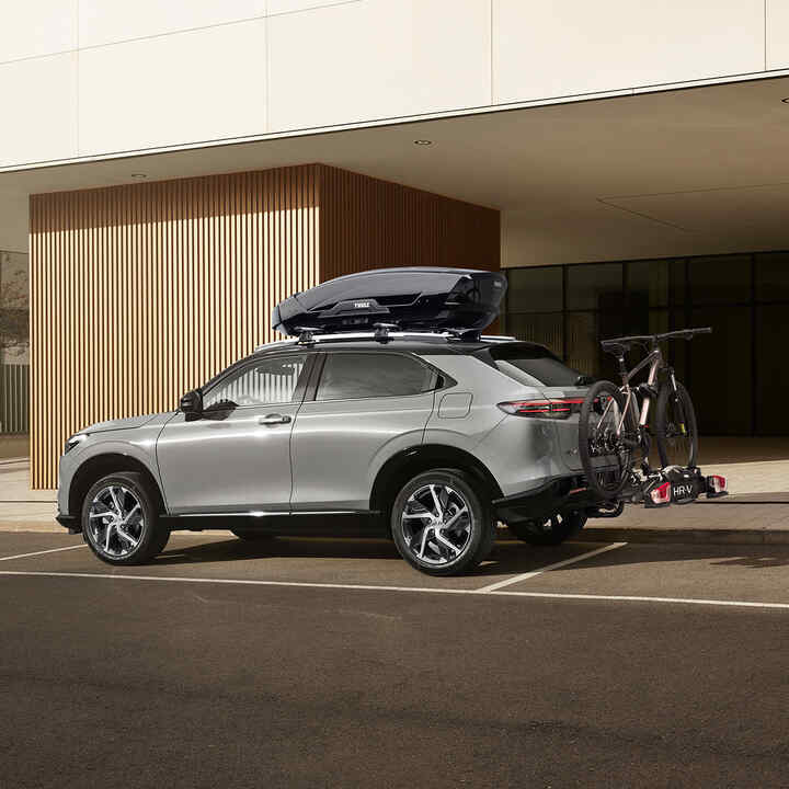 Neuer HR-V mit Dachbox vor einem Hotel geparkt