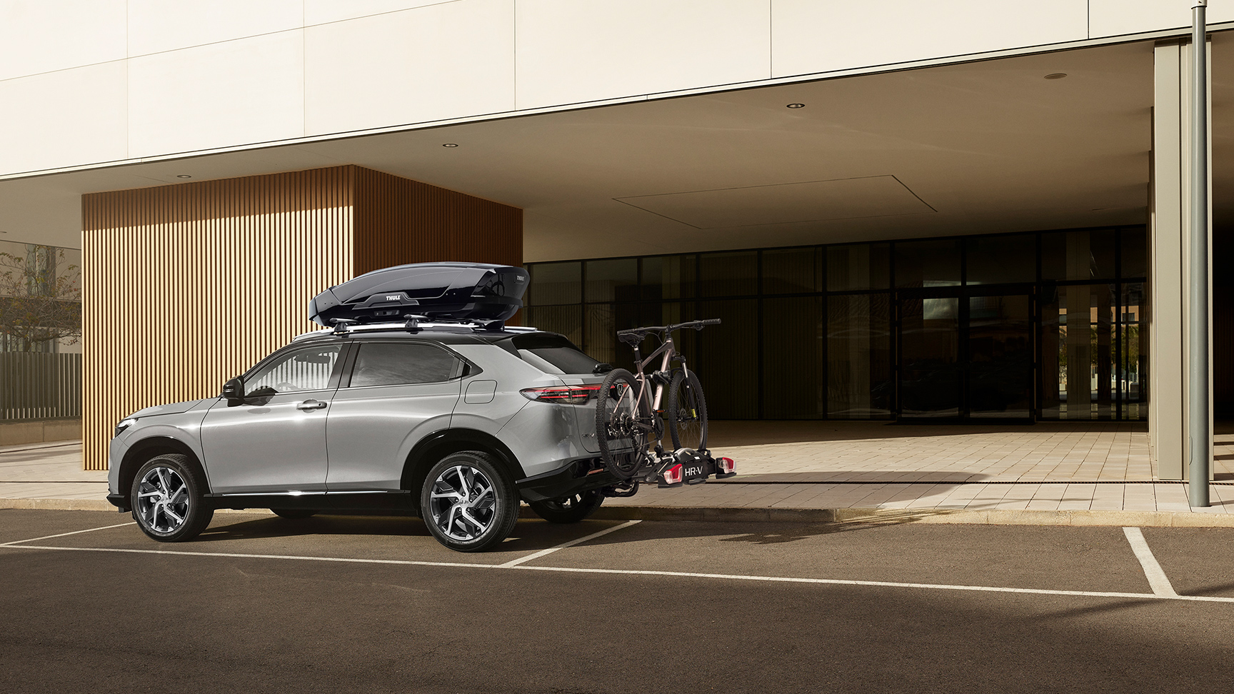 Neuer HR-V mit Dachbox vor einem Hotel geparkt