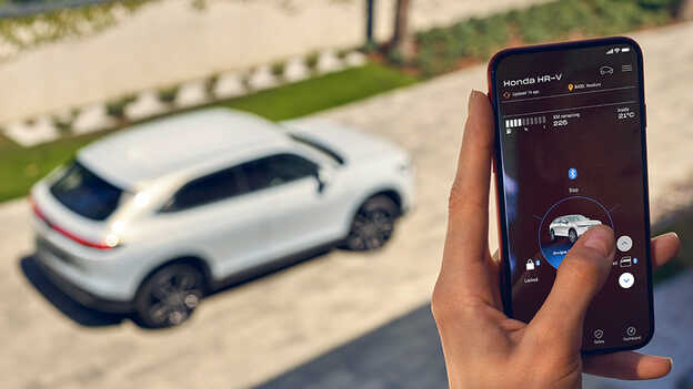 Eine Honda-Besitzerin nutzt die My Honda+ App auf ihrem Telefon.