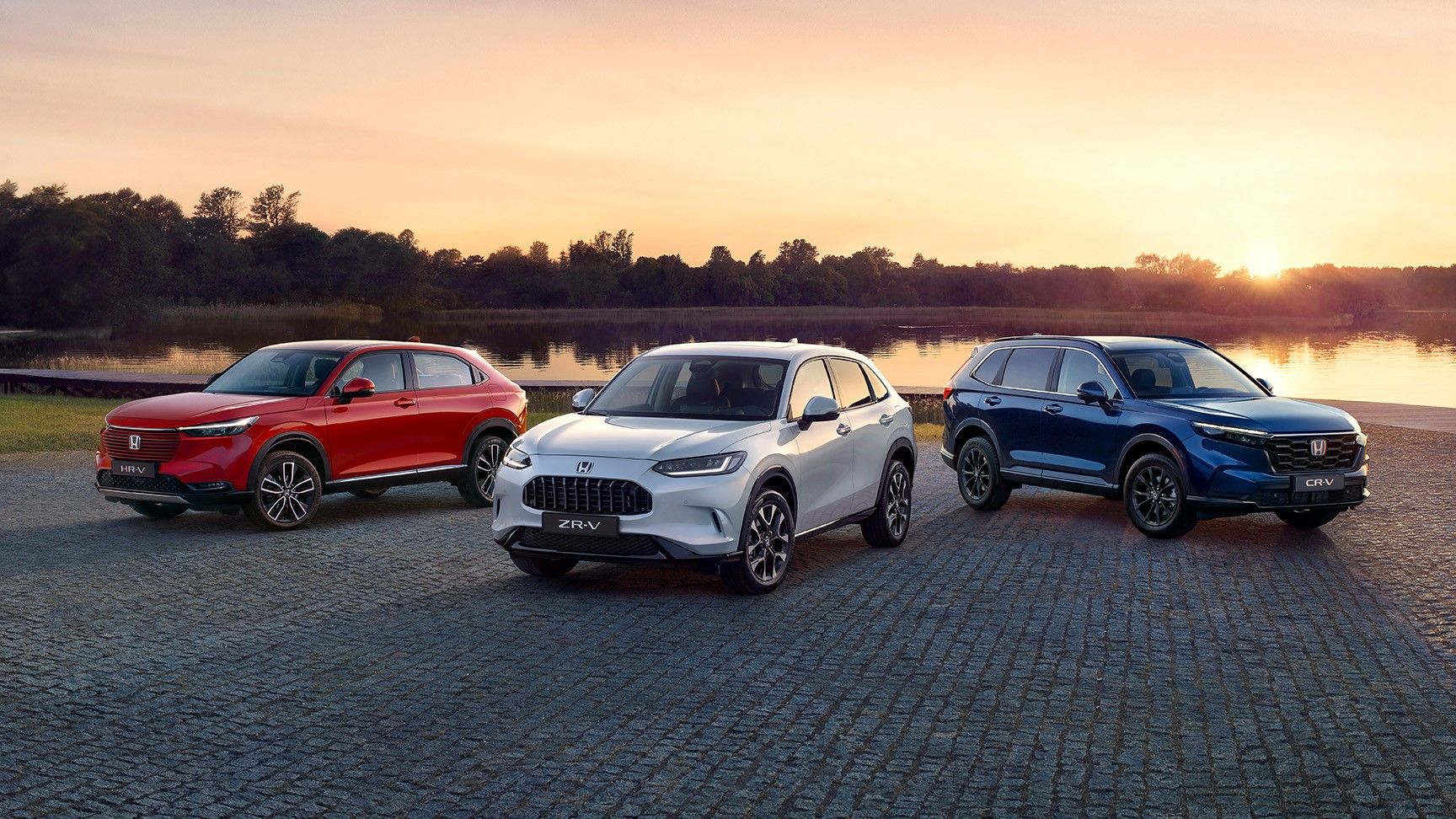 Verschiedene Honda Hybridfahrzeuge vor Stadtkulisse