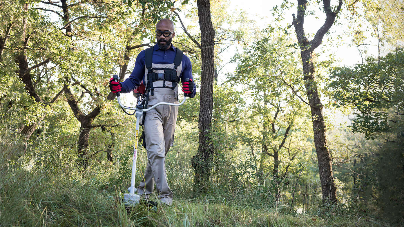 Mann mit Freischneider im Wald