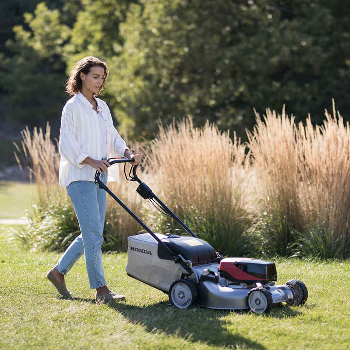 Model with izy-ON mower in a garden location.