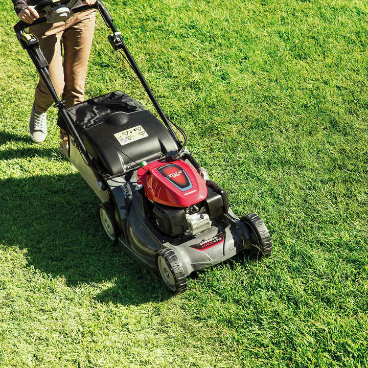 Honda HRX-Rasenmäher, Dreiviertelfrontansicht in einem Garten.