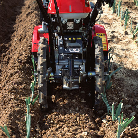 Nahaufnahme einer Motorfräse, Gartenumgebung.