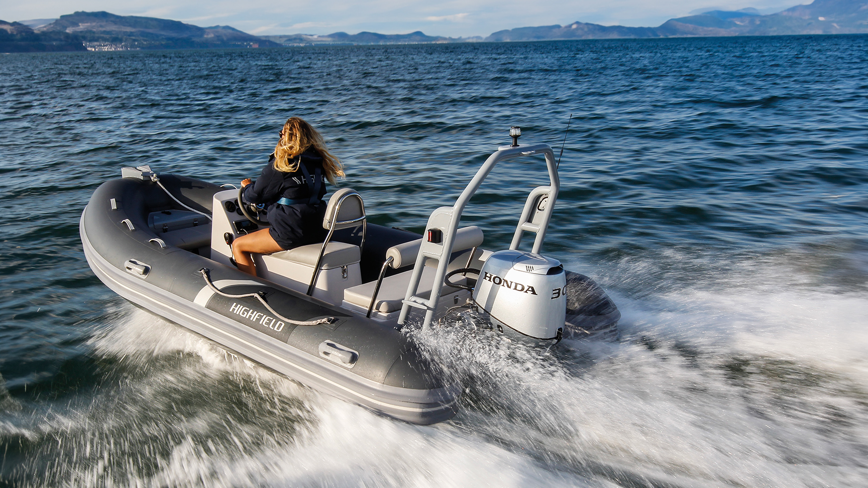 Frau auf einem Highfield-Boot mit Honda BF30-Motor in maritimer Umgebung.