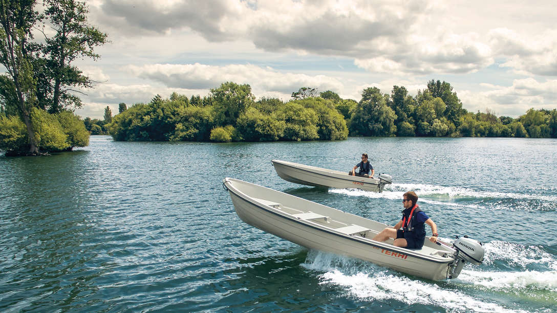 Zwei Boote rauschen über einen See