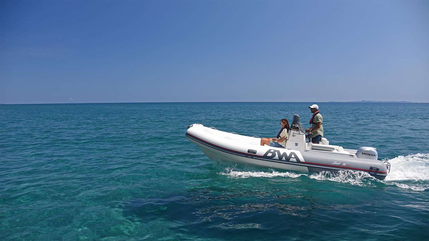 Paar fährt in einem aufblasbaren Schnellboot mit einem Honda Außenbordmotor BF50