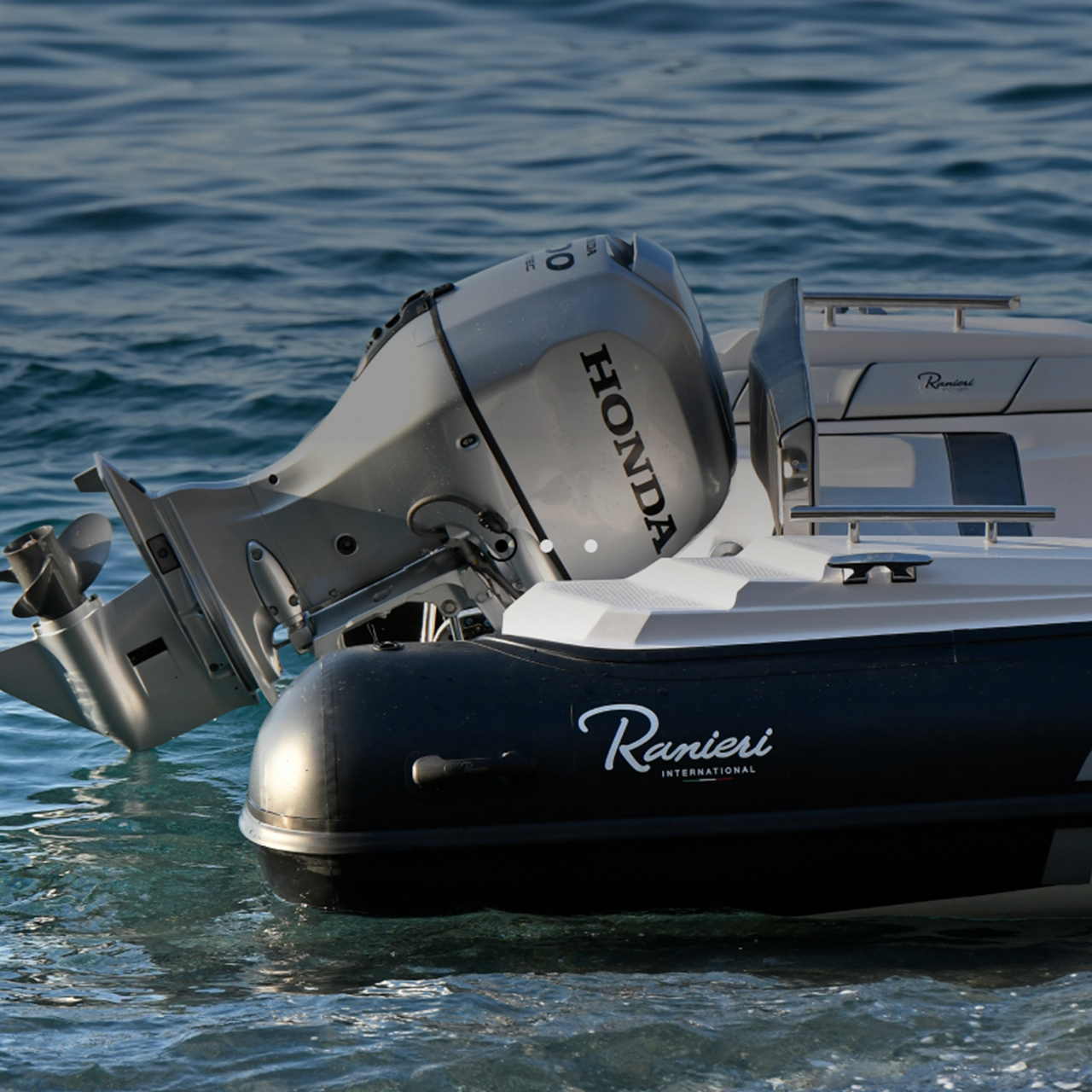 Nahaufnahme des Honda BF80-100-Motors am Heck eines Bootes in maritimer Umgebung.