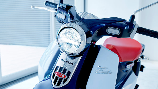 Geparkte Honda Super Cub in moderner Umgebung.