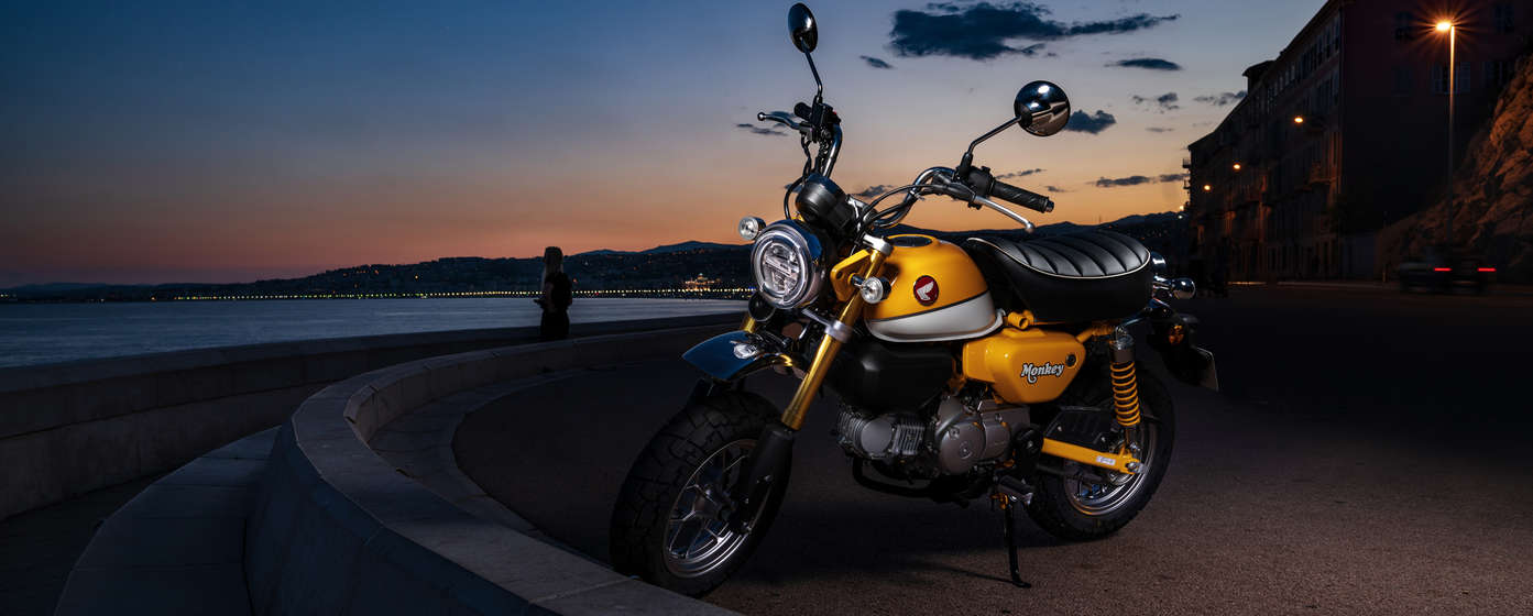 Geparkte Honda Monkey vor einem Strand.