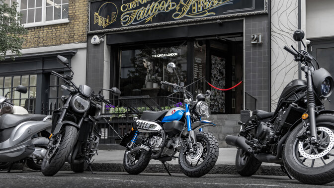 Honda Monkey auf Seitenständer auf der Straße mit Fahrer