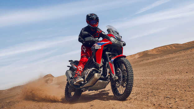 Model auf einer CRF1100L Africa Twin in einer Wüste.