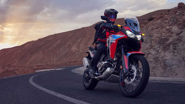 Model mit einem CRF1100L Africa Twin-Motorrad in einer Wüste.