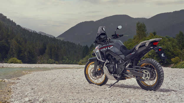 Der Fahrer hält das XL750 Transalp-Motorrad in einer Berglandschaft.