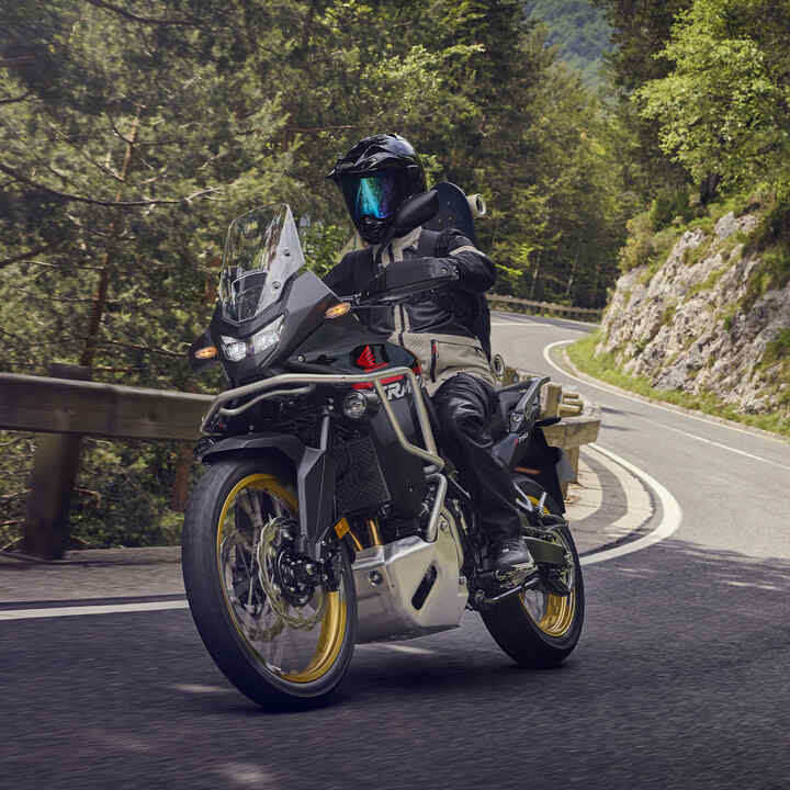 Das Model fährt mit dem Motorrad XL750 Transalp in den Bergen.
