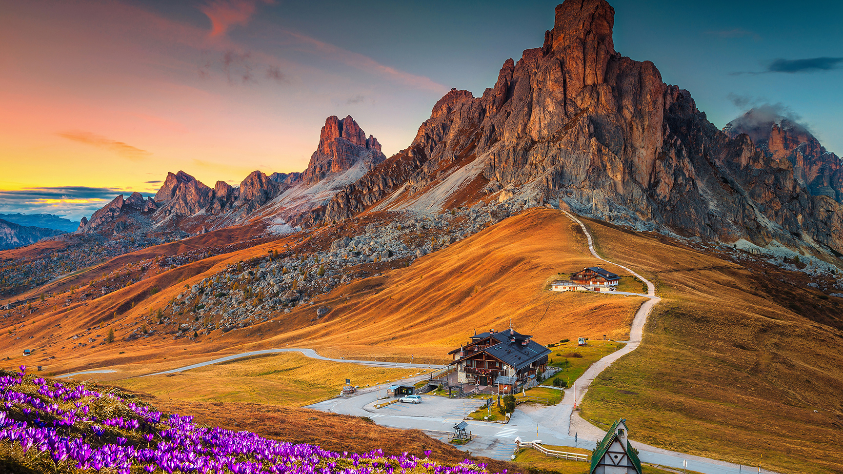 Wunderschöne Alpenlandschaft mit blühenden Frühlings-Krokussen und spektakulären Bergen im Sonnenuntergang, Giau-Pass, Dolomiten, Italien, Europa