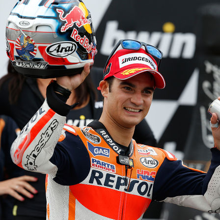 Fahrer auf MotoGP-Podium mit Pokal.