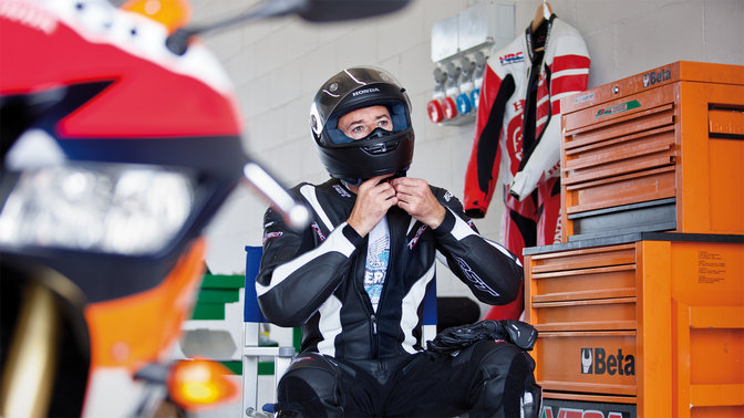 MotoGP-Fahrer mit Motorradkleidung und Helm.