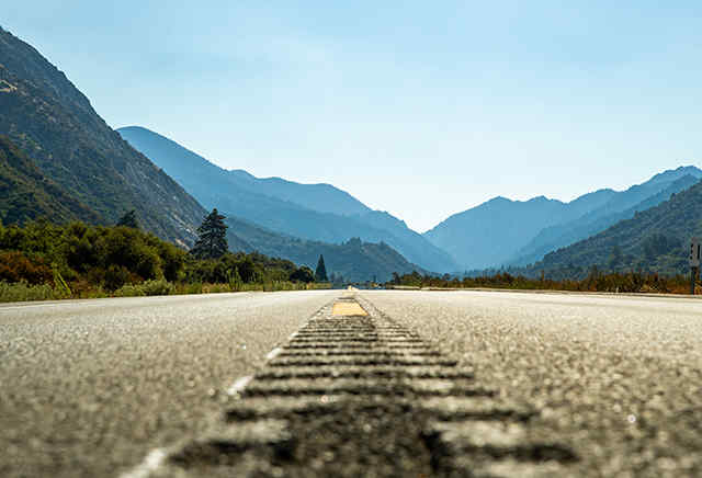 Offene Asphaltstraße vor einem Gebirge