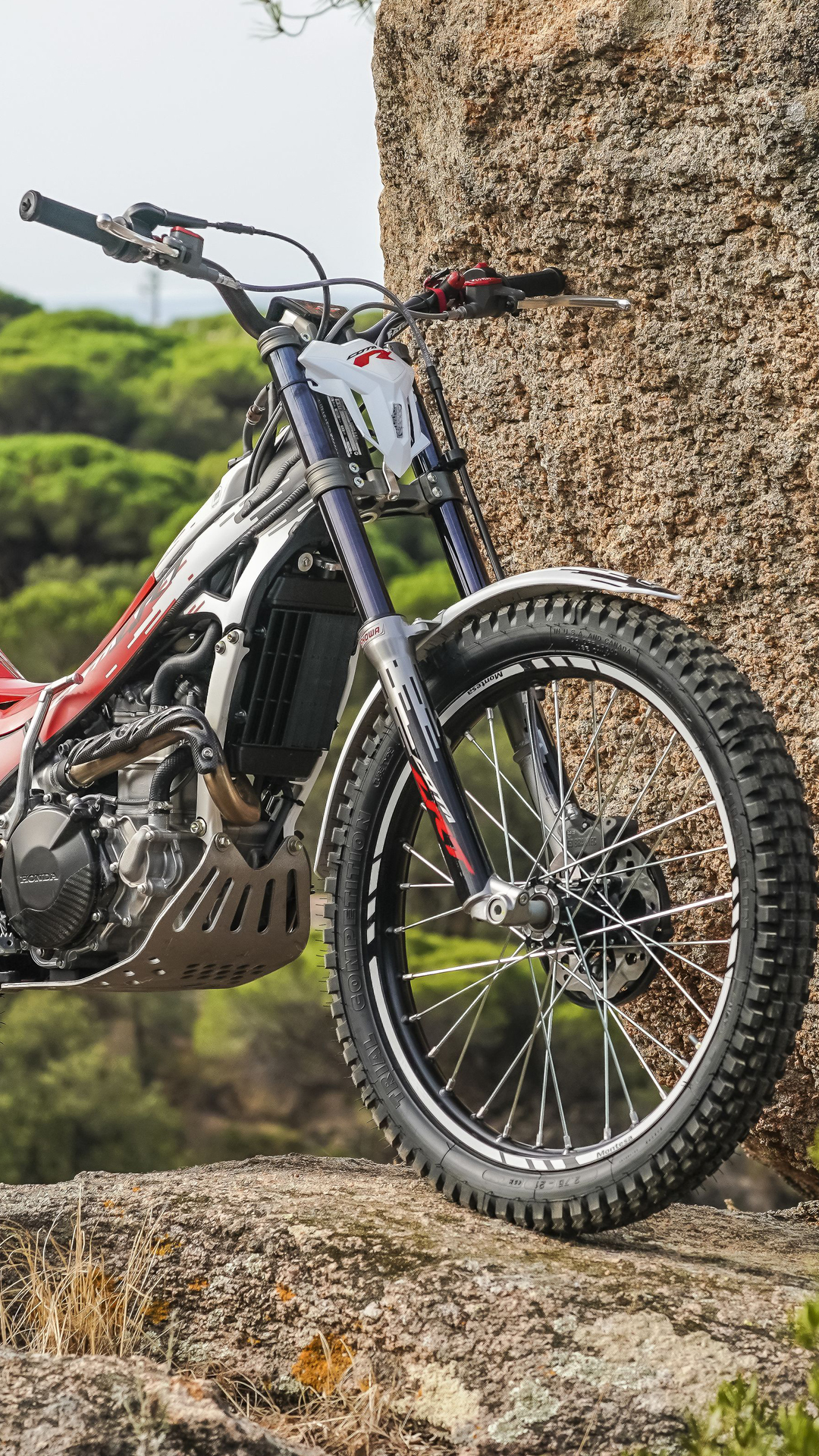 Ein Montesa Cota 301RR Trial-Motorrad auf felsigem Gelände im Freien.