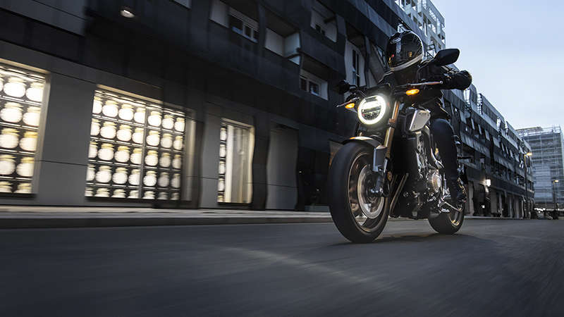 CB650R Neo Sports Café, 3/4-Ansicht links, in der Stadt mit Fahrer
