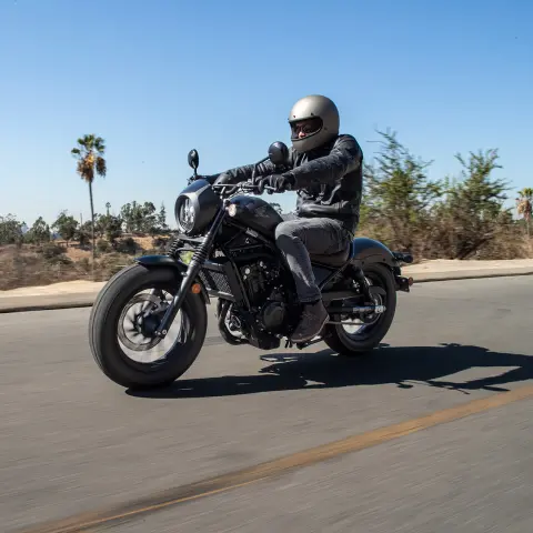Honda CMX500 Rebel mit männlichem Fahrer auf der Straße. 