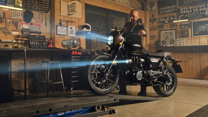 GB350S, ¾-Frontansicht mit Fahrer bei Arbeiten am Motorrad