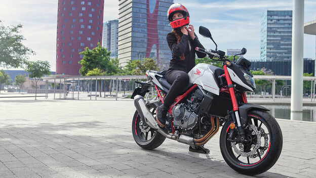 Statisches Bild der Honda CB750 Hornet mit weiblicher Fahrerin.