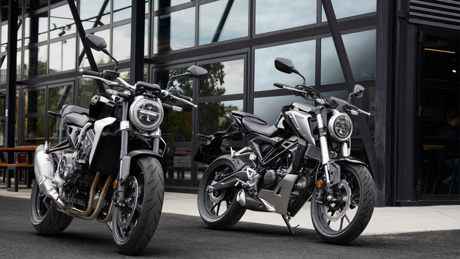 Honda CB1000R und CB125R, abgestellt auf einer Strasse.
