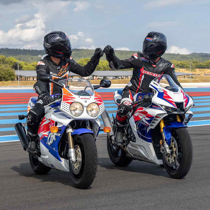 Frontansicht von zwei Honda Fireblades mit Fahrern, die sich auf der Rennstrecke begrüßen.