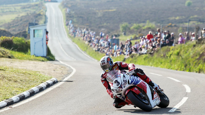 3/4-Frontansicht einer Honda Fireblade, nach links weisend, mit Fahrer auf der Rennstrecke.