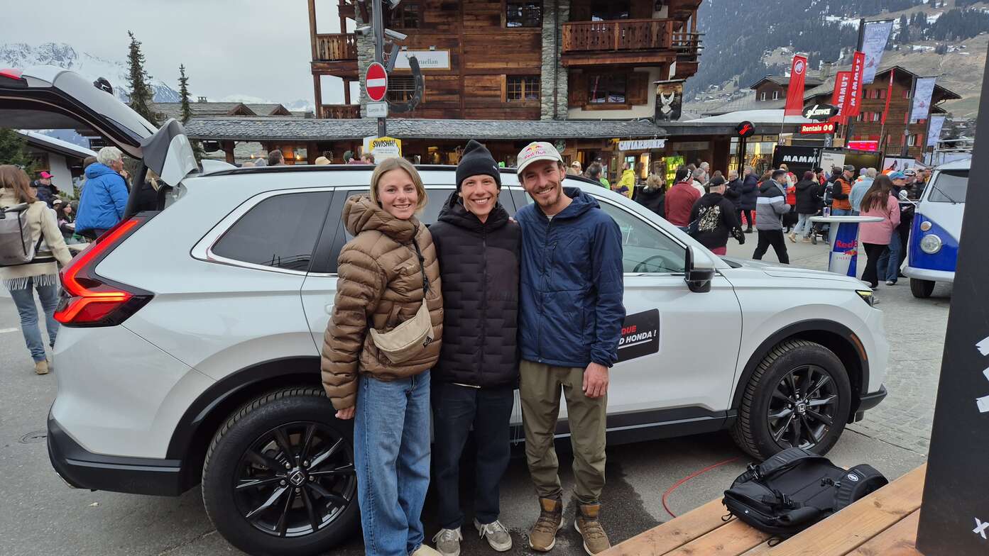 3 Freerider posieren vor dem Honda CR-V Hybrid am Honda-Stand in Verbier.