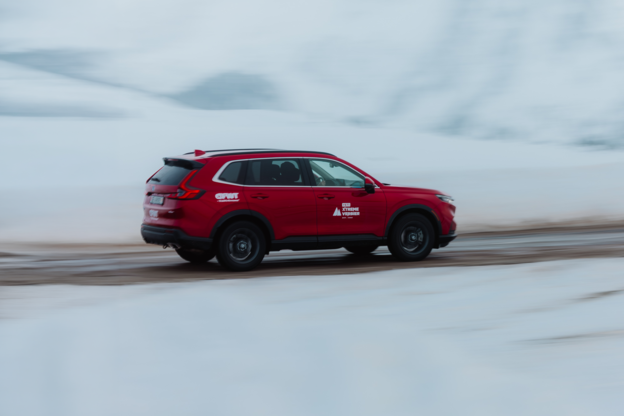 CR-V 4x4 rot mit Freeride World Tour-Aufklebern auf einer verschneiten Strasse