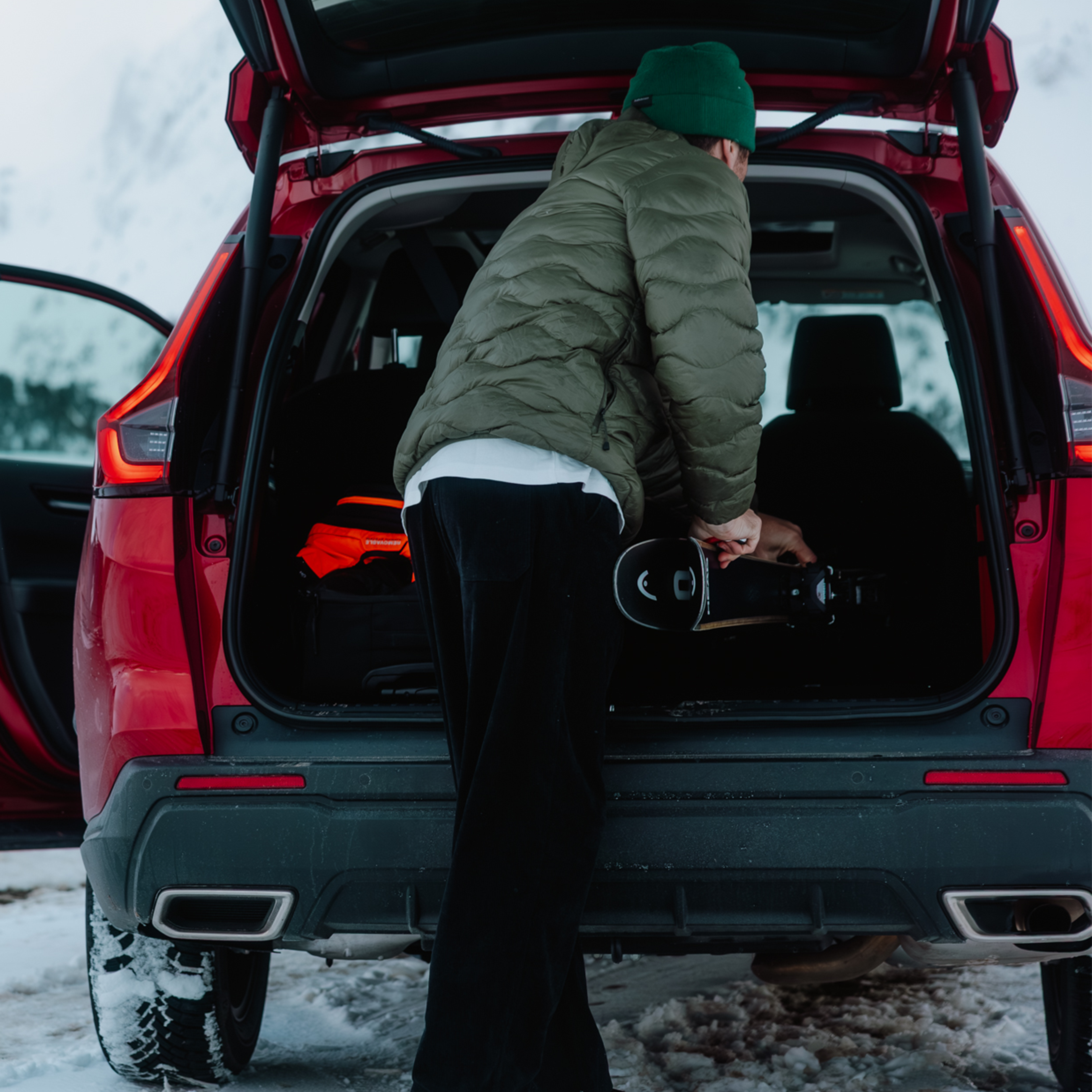 Eine Person lädt Skier in den Kofferraum des CR-V AWD.