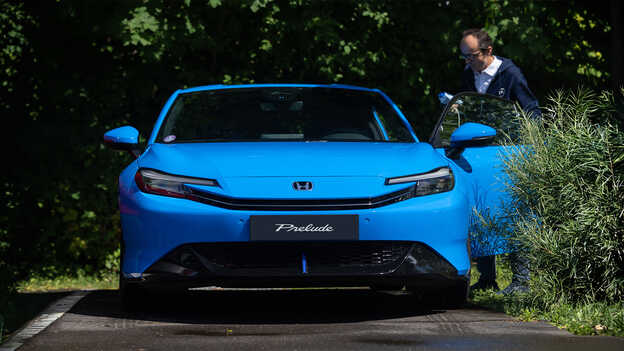 Ein blauer Honda Prelude von vorne gesehen, mit einem Mann, der die Fahrertür öffnet