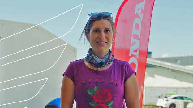 Un pilote de moto à l’arrêt près d’un passage piétons dans une rue.