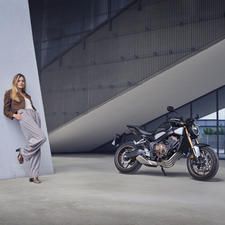 Model auf einem Motorrad im Gebirge.
